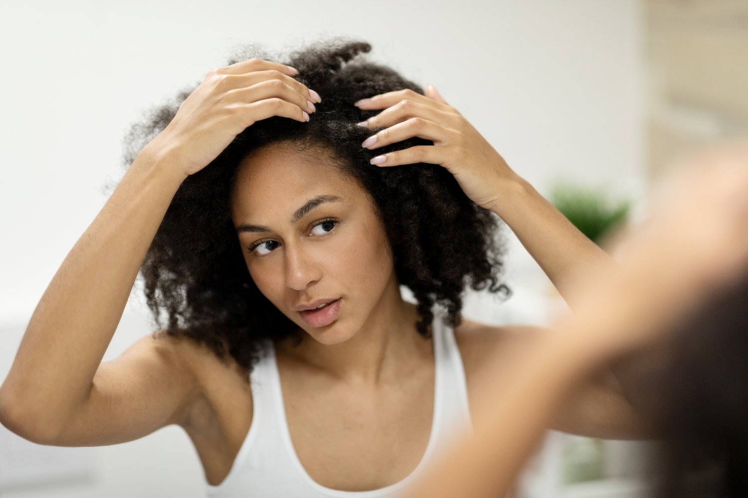 Woman checking her scalp and hairline in a mirror